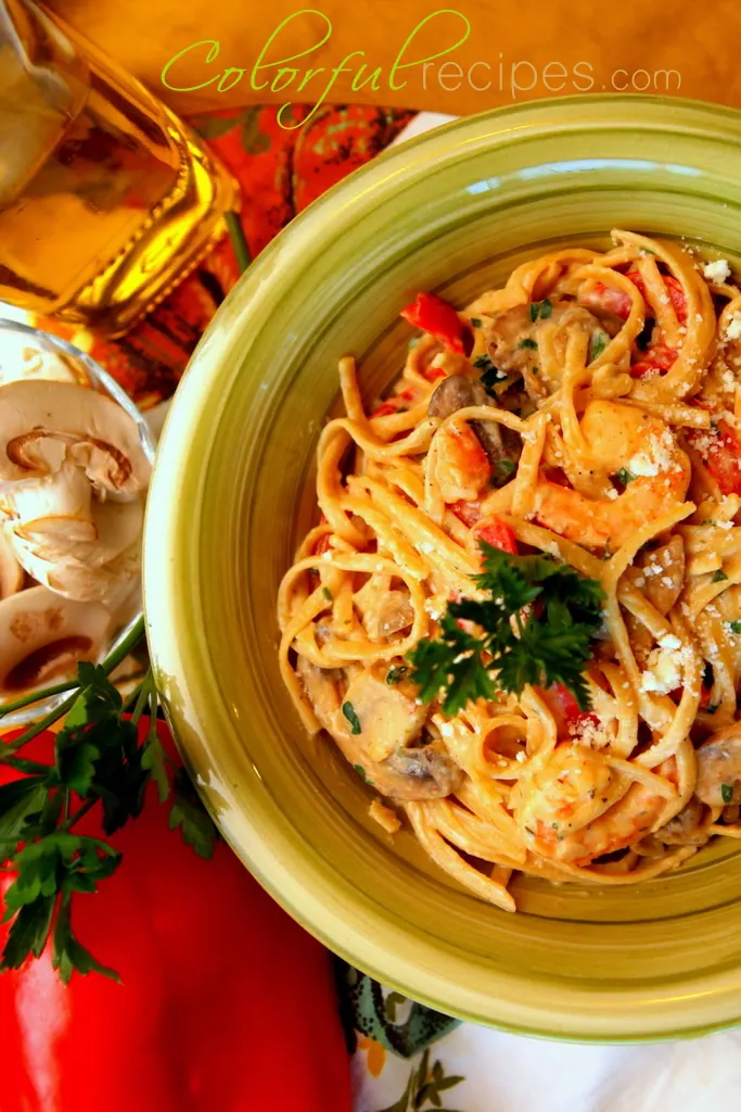 Bowl of creamy shrimp linguine with mushrooms, red bell pepper and parsley