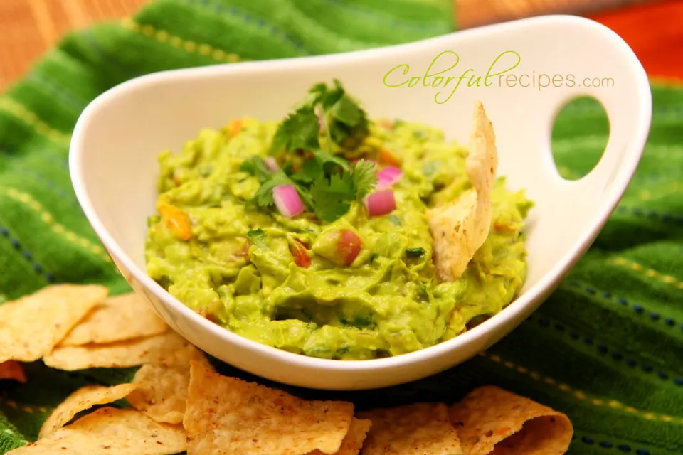 Fast easy guacamole in a white bowl with tortilla chips