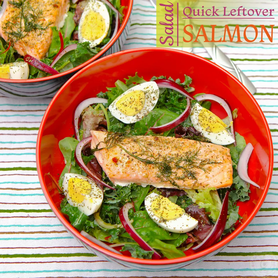 Quick leftover salmon salad with a salmon fillet, boiled egg and red onion in a red bowl
