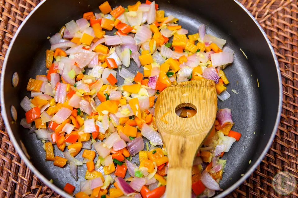 Sautéing onion, garlic and mini peppers for artichoke spinach dip