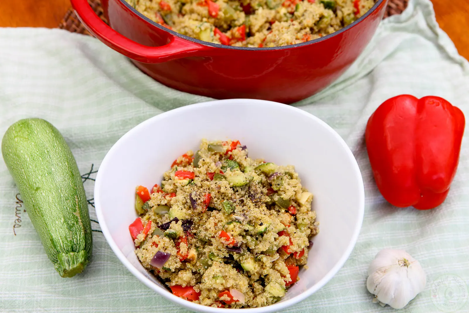 Bowl of roasted veggie quinoa pilaf with red and green peppers and zucchini
