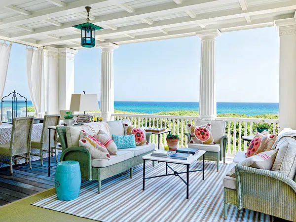 Breezy beach house porch with couches overlooking the ocean