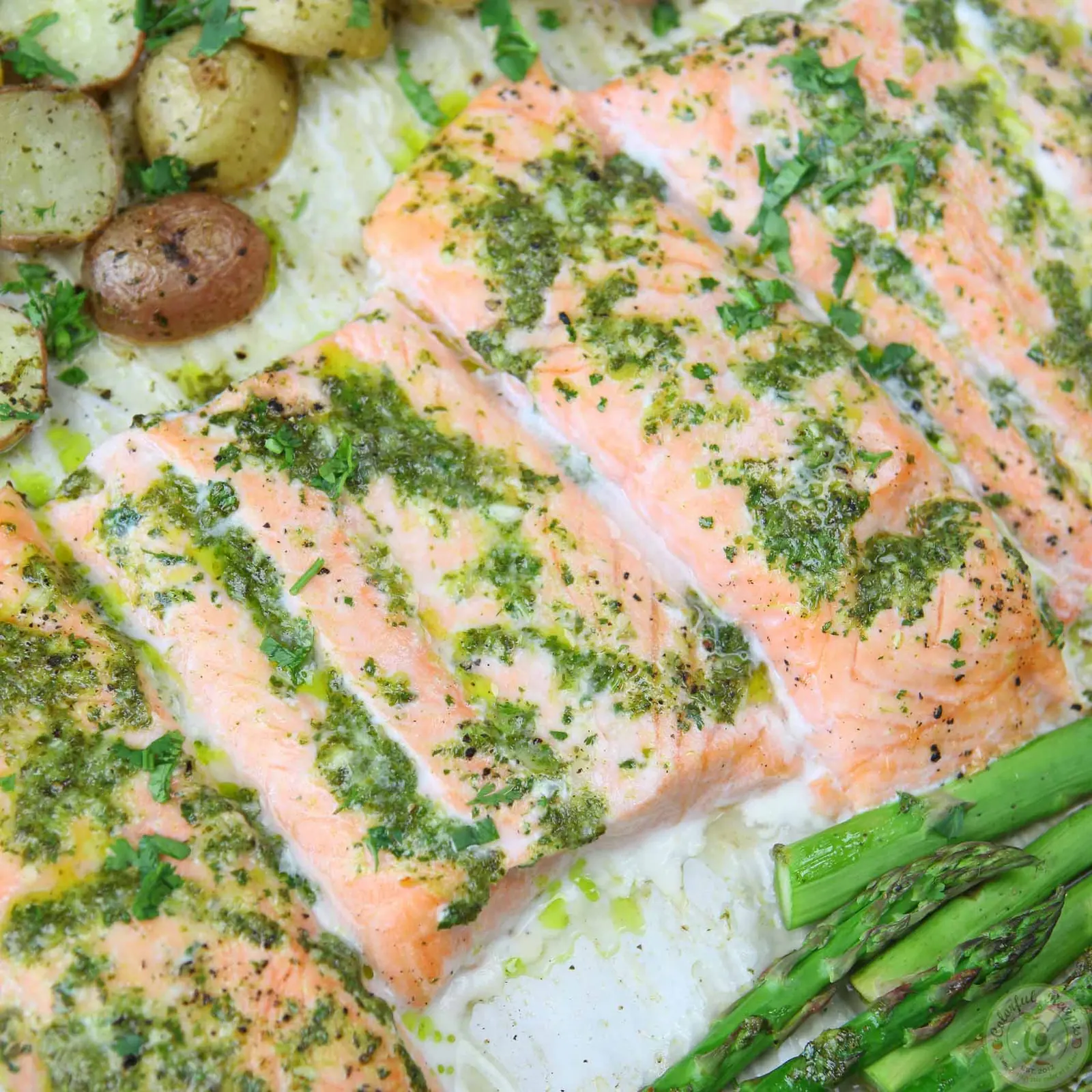 Close-up of one pan salmon topped with cilantro garlic citrus butter, with asparagus and potatoes