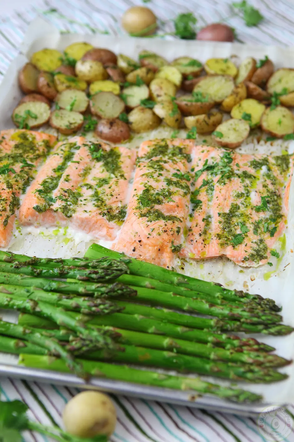 One pan salmon and veggies with roasted potatoes, salmon fillets and asparagus on a sheet pan