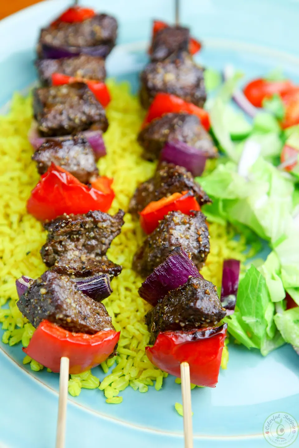 Easy broiled beef kabobs with red pepper and red onion on turmeric rice