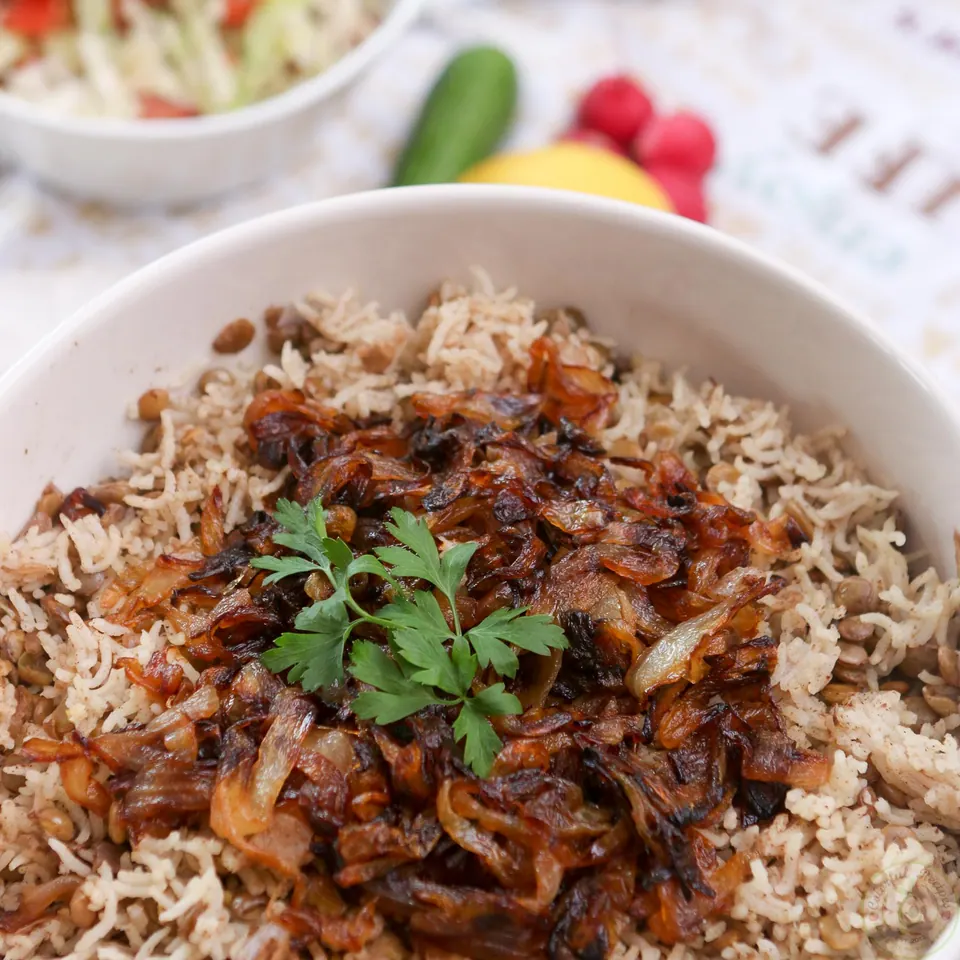 Mdardara lentil rice pilaf served with cabbage tomato salad on a summer deck