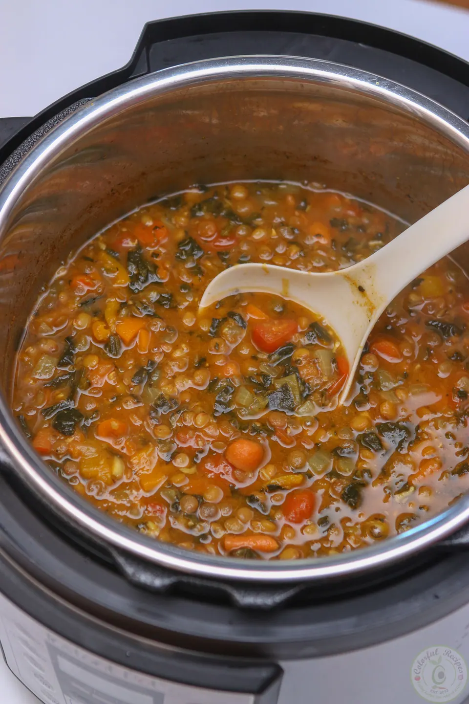 Instant Pot full of hearty lentil soup with carrots and spinach