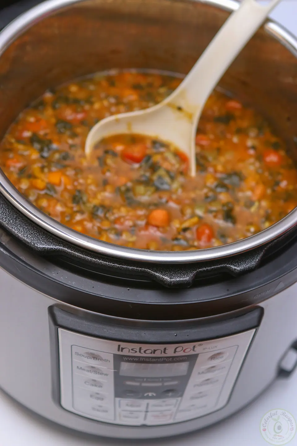 Lentil spinach soup in the Instant Pot with a ladle