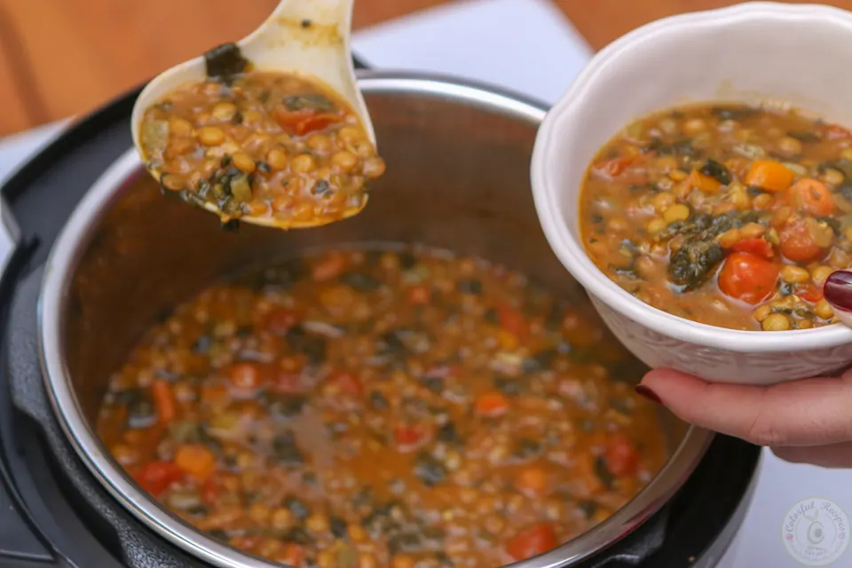 Serving a ladle of Instant Pot lentil spinach soup from the pot