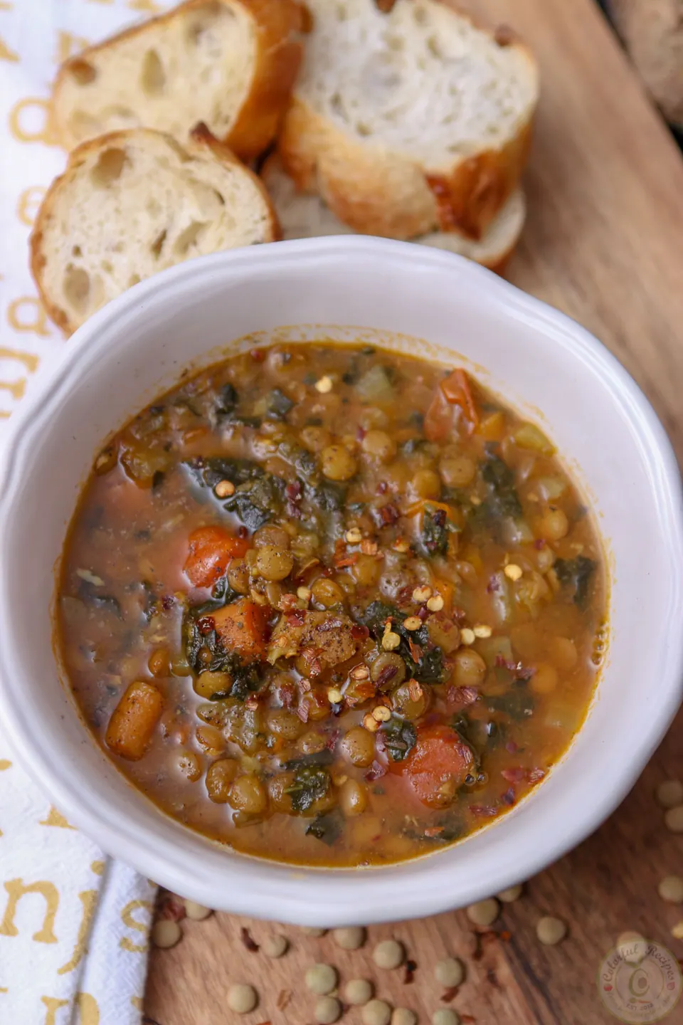 Bowl of Instant Pot lentil spinach hearty soup with crusty bread